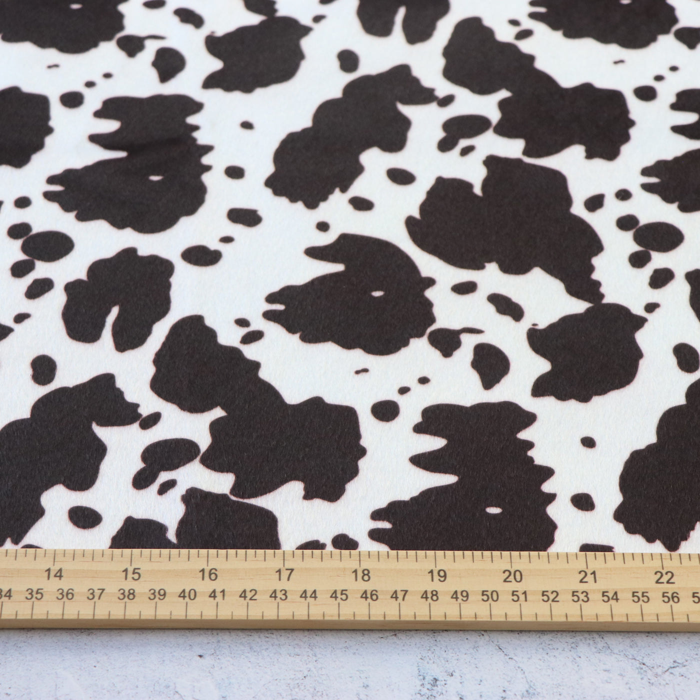 Corte empaquetado de 1/2 yarda: Piel sintética blanca y negra de vaca